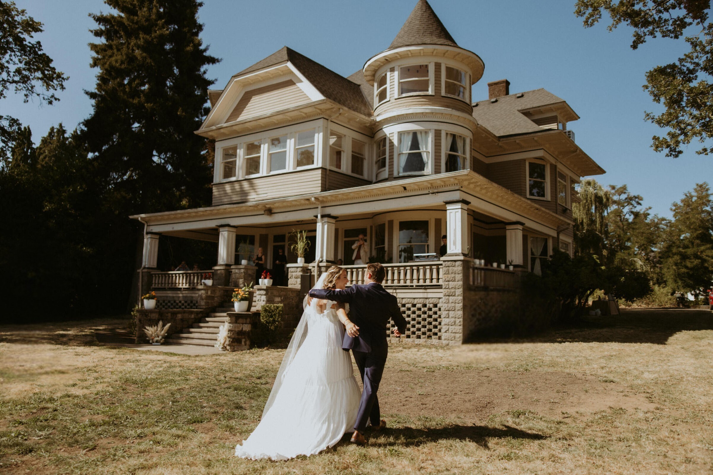 Bride and groom walking hand-in-hand down the aisle after their ceremony at St. Johns Inn, with the historic home and lush greenery providing a romantic backdrop.